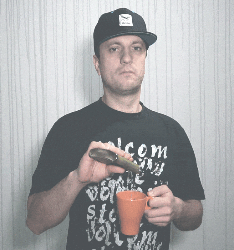 Kirill Kusnetzow wie er Flüssigkeit aus Flachmann in orange Tasse gießt