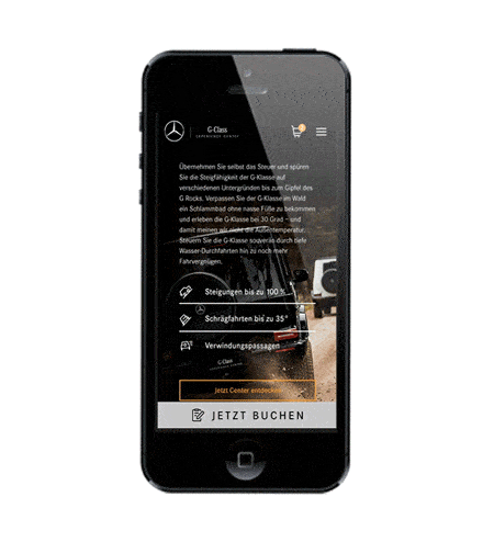 Ein Smartphone zeigt die mobile Website des „G-Class Experience Center“. Der Text bewirbt Offroad-Fahrten mit technischen Highlights wie Steigungen bis zu 100 % und Schrägfahrten bis 35°. Ganz unten befinden sich auffällige Buttons mit den Aufschriften „Jetzt Center entdecken“ und „JETZT BUCHEN“.