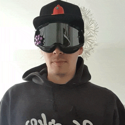 Christian trägt Cappy und Skibrille und isst Eis