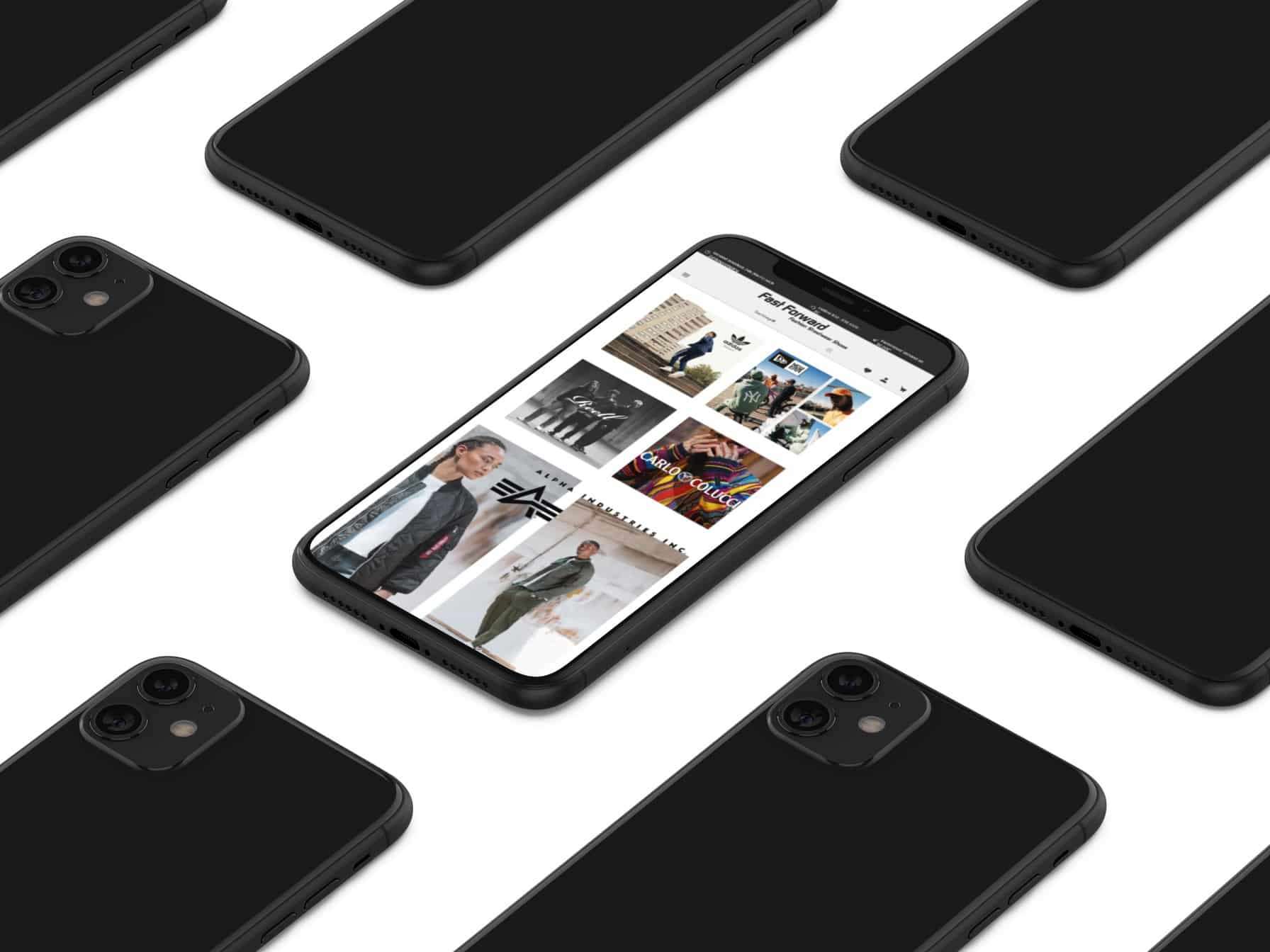 schwarze Handys, die umgedreht auf einem weißen Tisch liegen. Das Handy in der Mitte liegt mit dem Display nach oben und zeigt die Website von fast forward