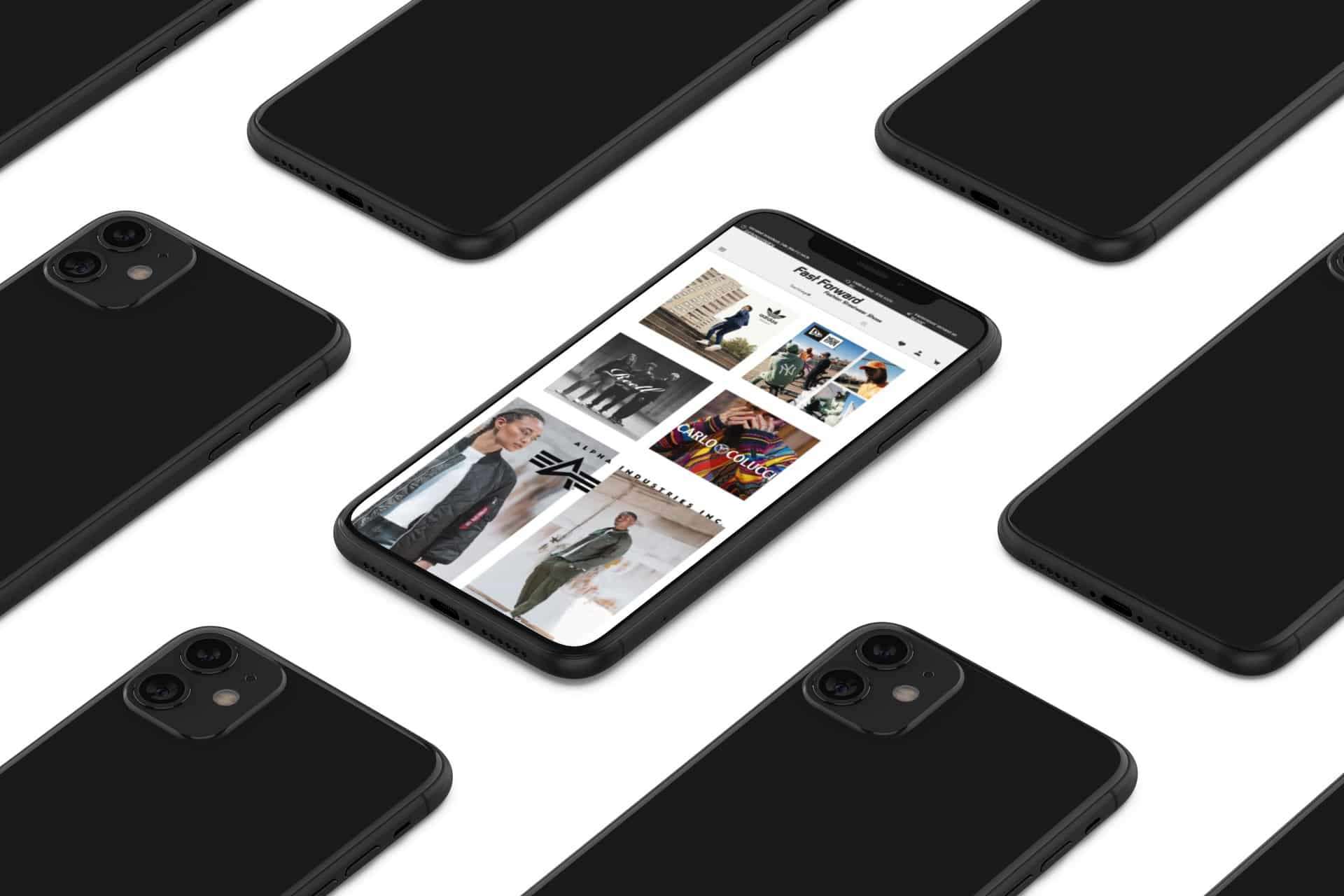 schwarze Handys, die umgedreht auf einem weißen Tisch liegen. Das Handy in der Mitte liegt mit dem Display nach oben und zeigt die Website von fast forward