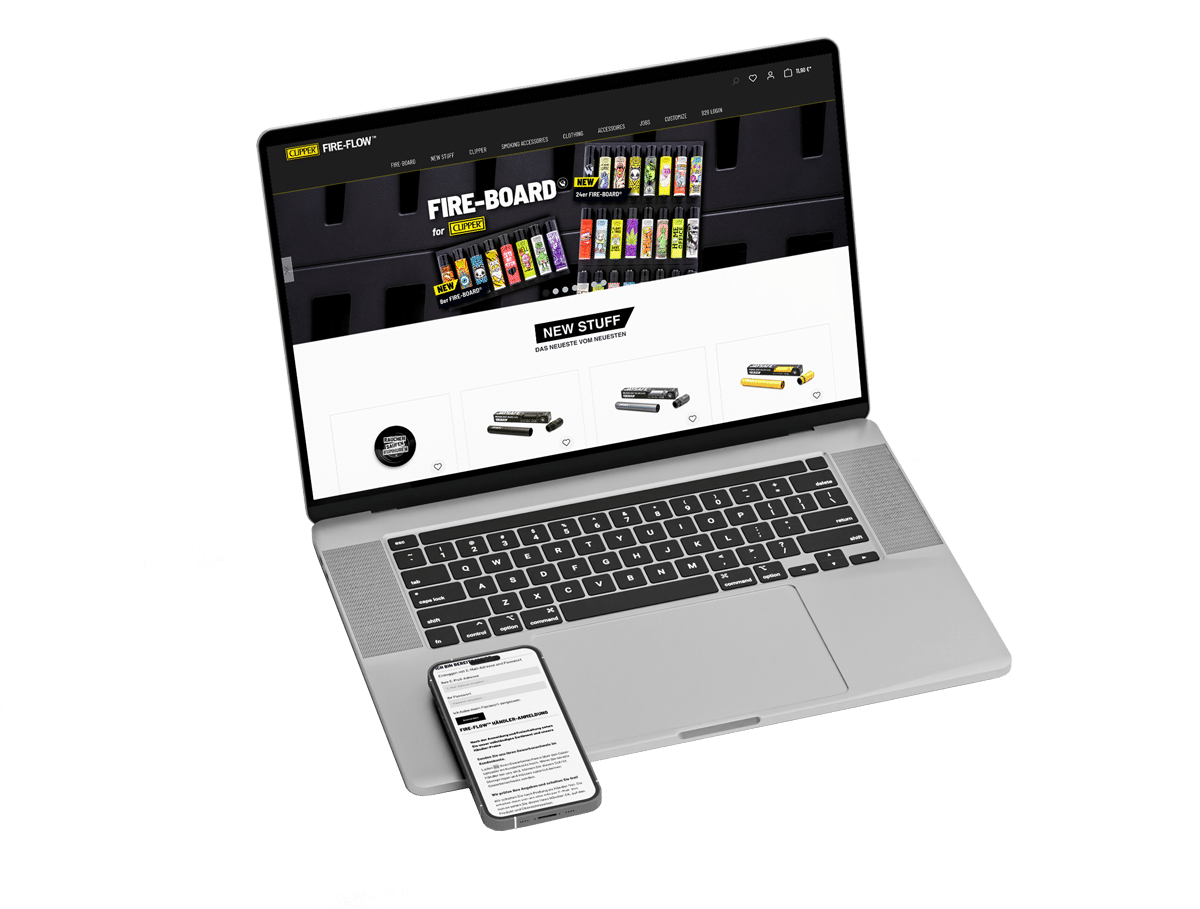 Grauer aufgeklappter Laptop auf dem ein Smartphone liegt. Auf dem Laptop Bildschirm sieht man die Website von Fireflow.